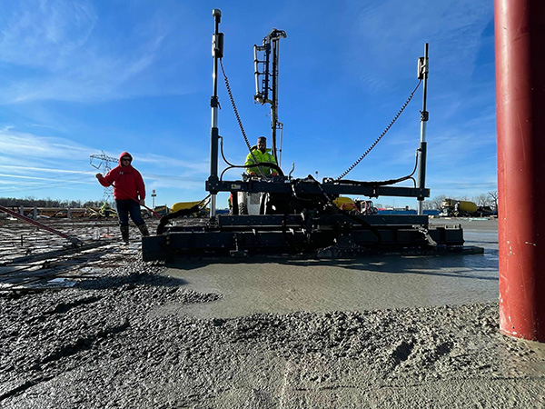 Close up of concrete professionals operating a  S-940 Laser Screed on a construction site. 