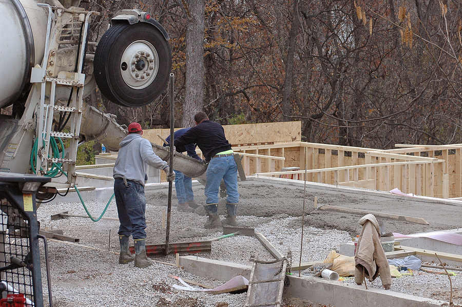 Construction workers pouring concrete at a construction site. 