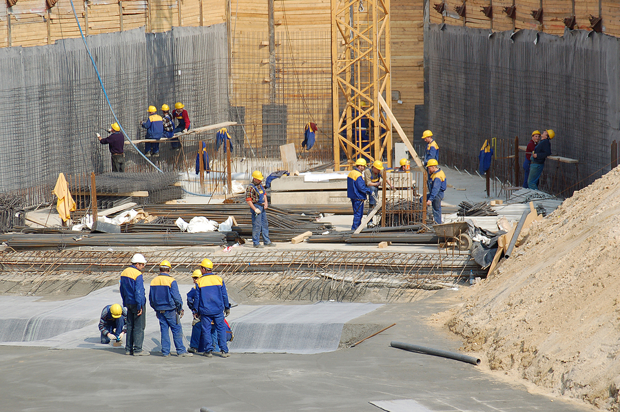 Concrete workers standing in the middle of a commercial construction project. 