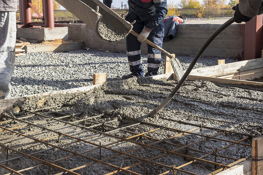 Workers pouring concrete at a construction site. 