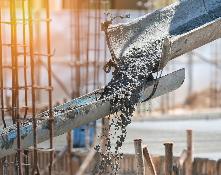 Closeup of concrete being poured at a large commercial construction site.