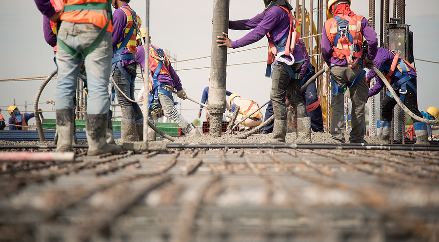 Construction workers pouring concrete at a construction site. 